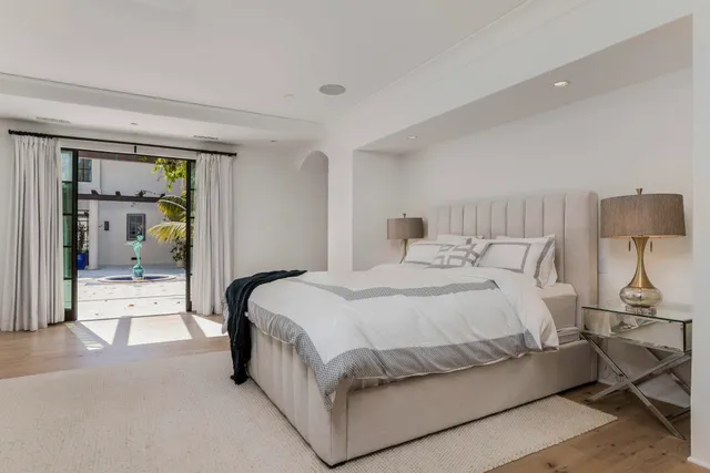 a spacious bedroom with a bed and lamp