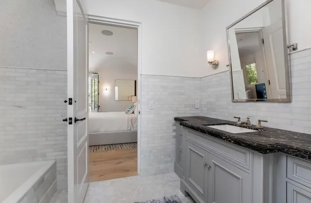 a bathroom with a granite countertop sink and a mirror