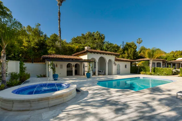 a front view of a house with swimming pool and porch