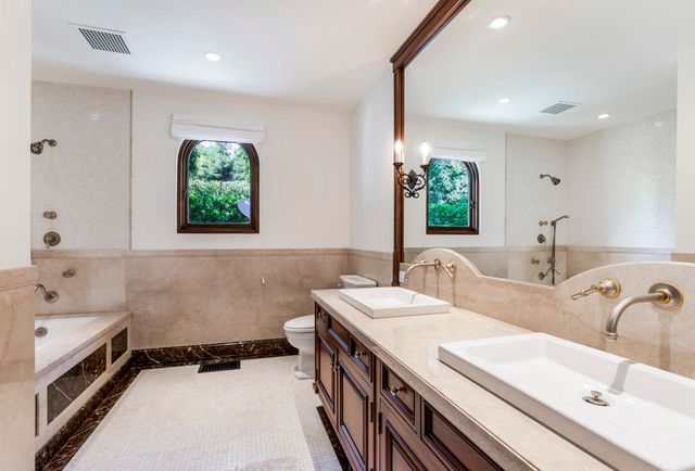 a bathroom with a double vanity sink window and a bathtub