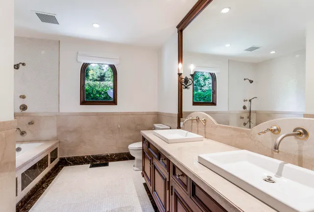 a bathroom with a double vanity sink window and a bathtub