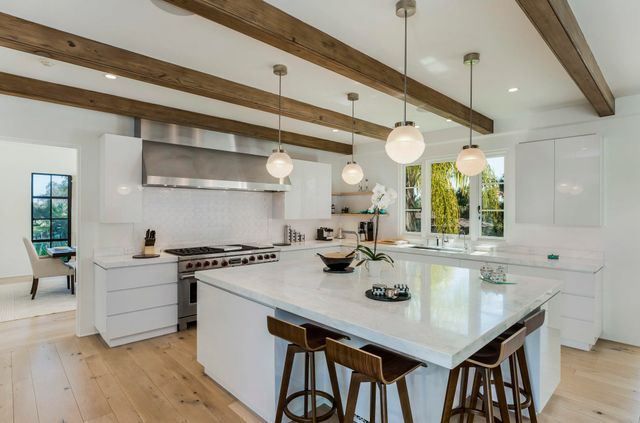 a kitchen with a table chairs and white cabinets
