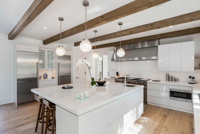 a kitchen with stainless steel appliances a sink a stove a refrigerator and cabinets