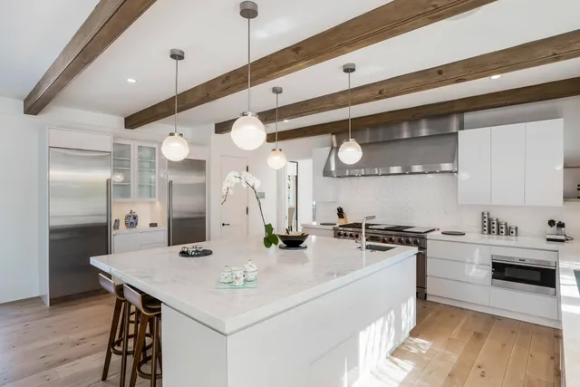 a kitchen with stainless steel appliances a sink a stove a refrigerator and cabinets
