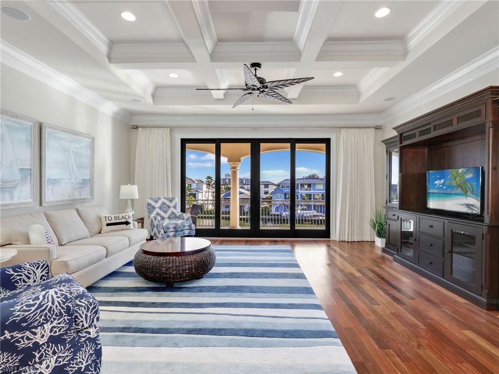 264 Bayview Avenue Naples, FL 34108 - Photo 31 of 50 a living room with furniture a flat screen tv and a floor to ceiling window