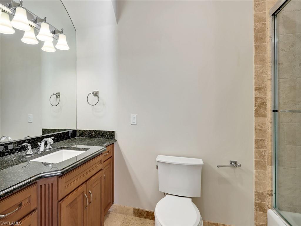 264 Bayview Avenue Naples, FL 34108 - Photo 38 of 50 a bathroom with a granite countertop sink vanity mirror and toilet