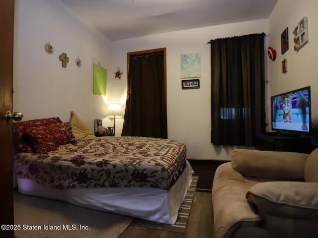 a bedroom with bed couch and window