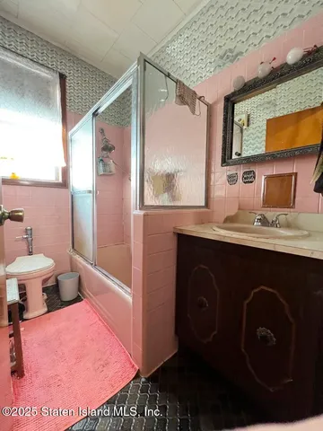a bathroom with a sink a toilet a mirror and shower