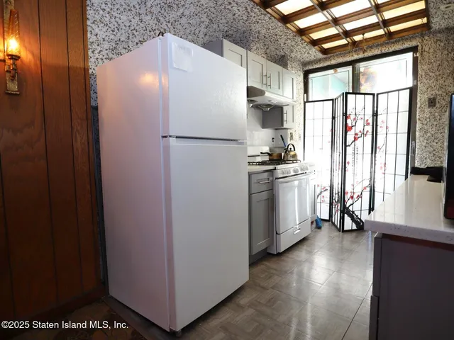 a kitchen with stainless steel appliances a refrigerator and a window