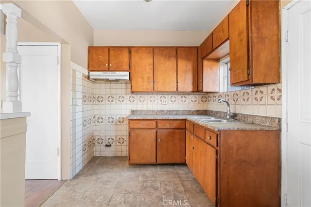 a kitchen with granite countertop a sink cabinets and a window