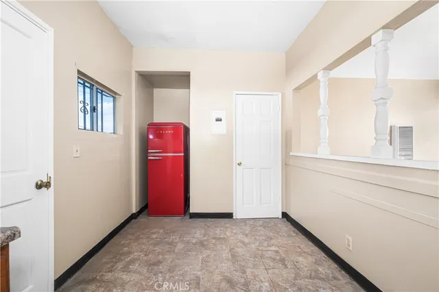 a view of an empty room with stairs and a window