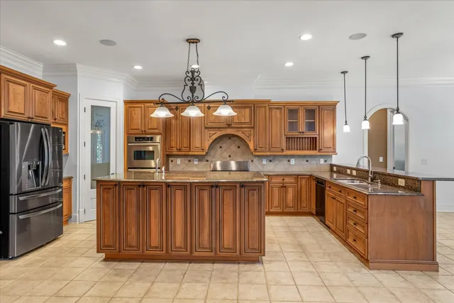 a kitchen with stainless steel appliances granite countertop a sink a stove and a refrigerator