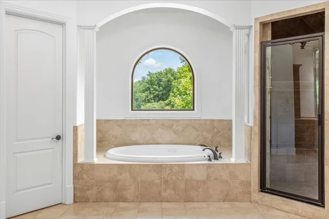 a bathroom with a tub sink and mirror
