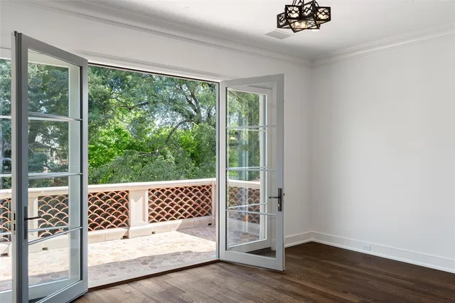 a view of a bedroom with wooden floor and balcony
