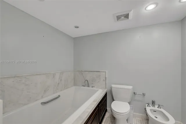 a white toilet sitting next to a bath tub