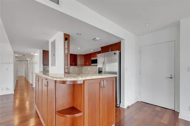 a kitchen with stainless steel appliances granite countertop a sink and a refrigerator