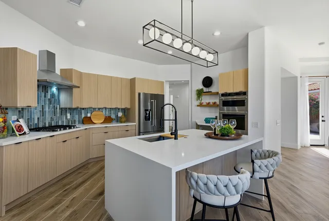 a kitchen with a dining table cabinets appliances and wooden floor