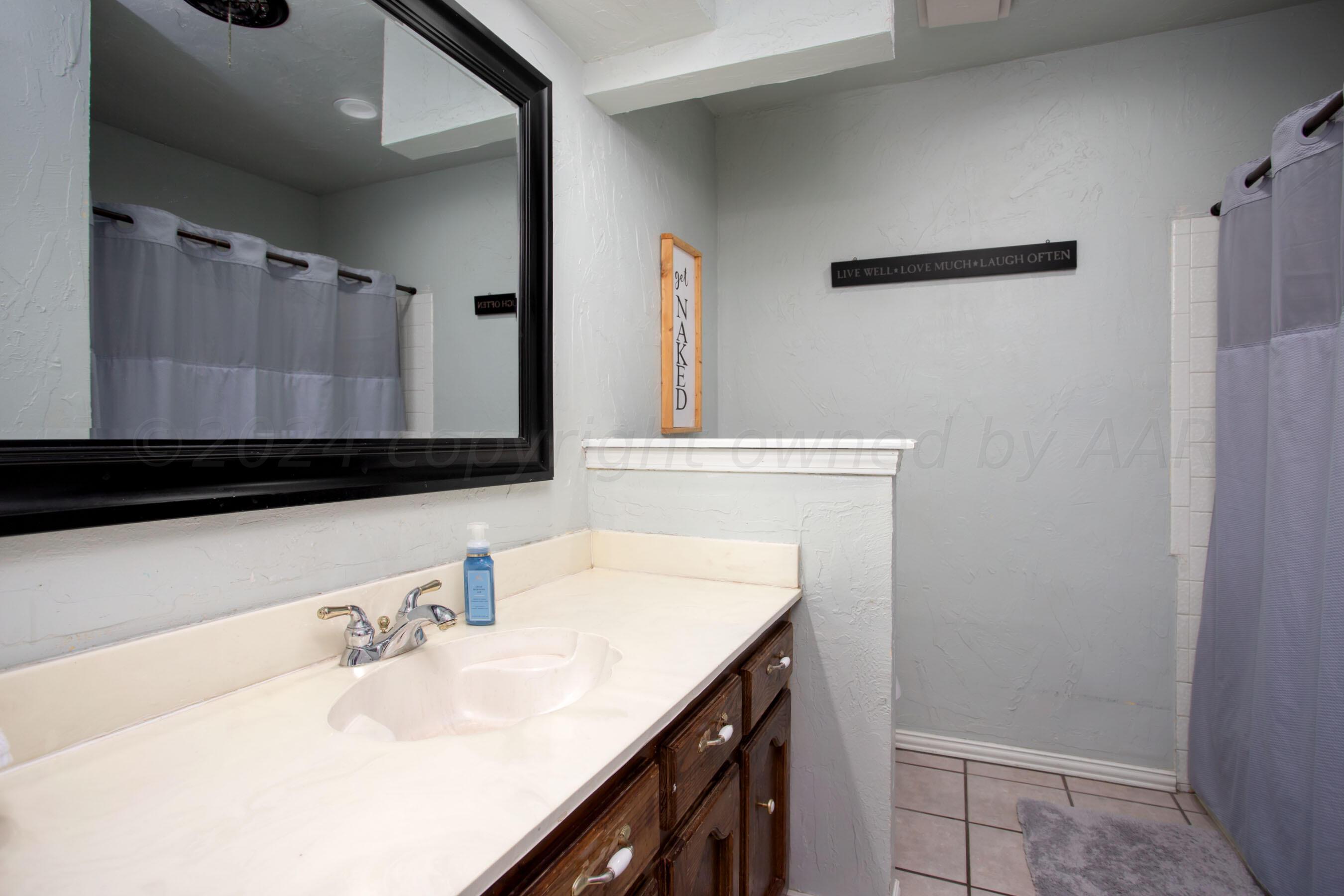 8122 Santa Fe Trail Amarillo, TX 79110 - Photo 12 of 23 a bathroom with a sink and a mirror