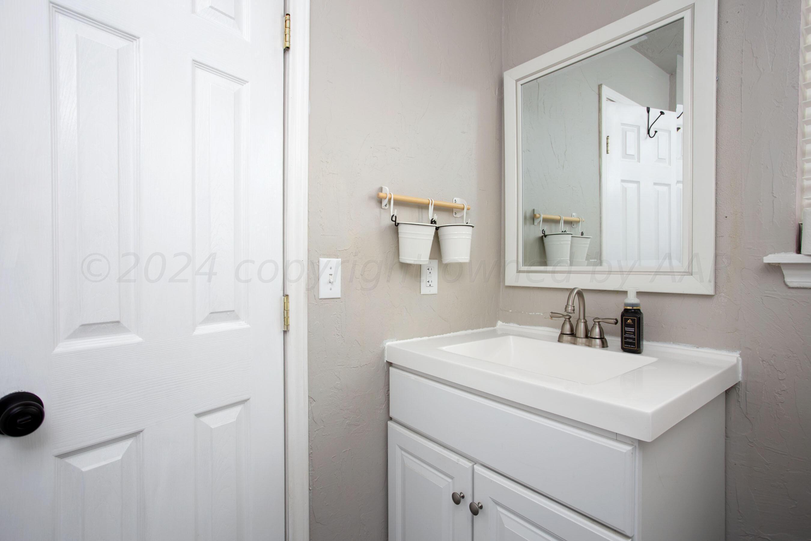 8122 Santa Fe Trail Amarillo, TX 79110 - Photo 17 of 23 a bathroom with a sink and a mirror