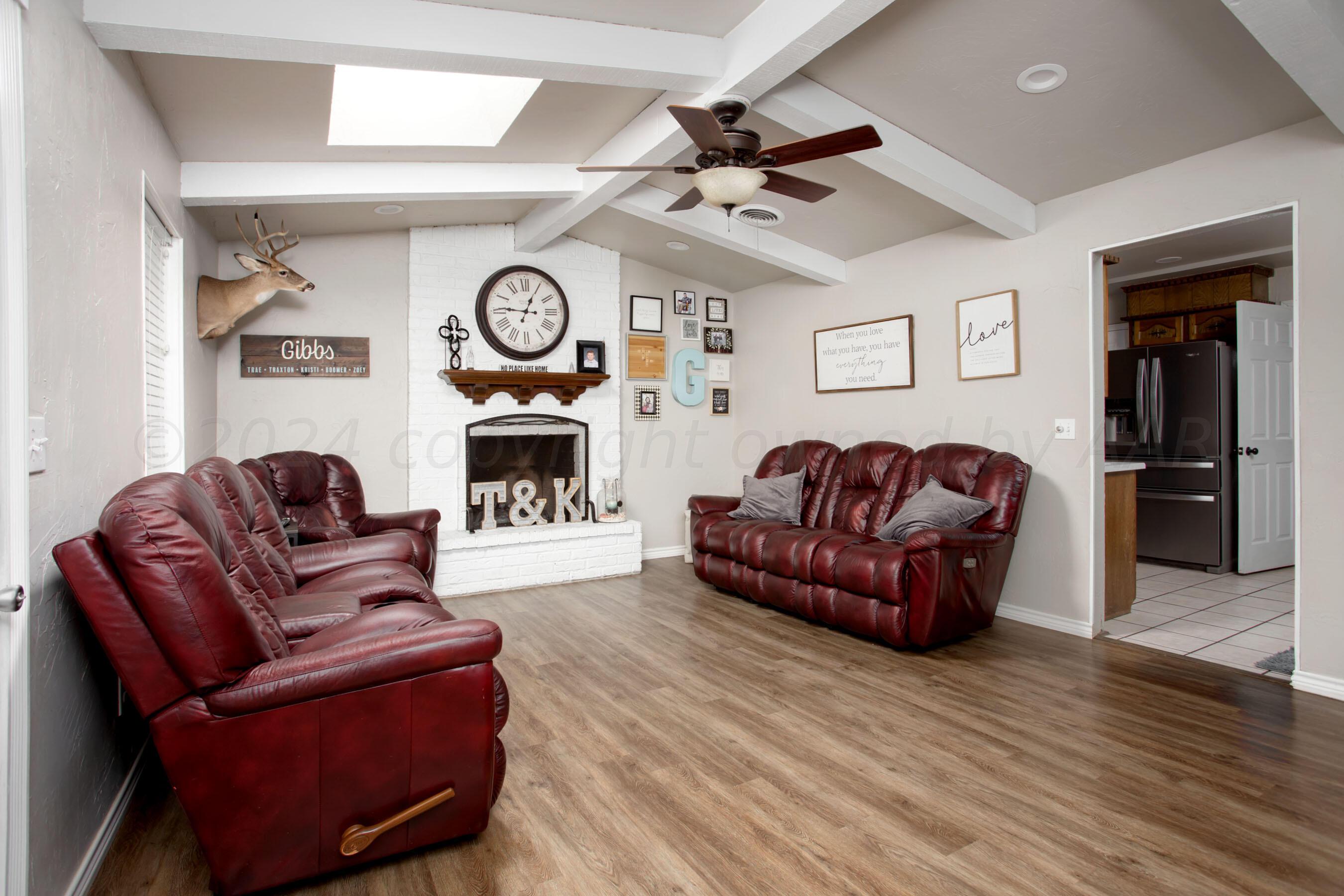 8122 Santa Fe Trail Amarillo, TX 79110 - Photo 3 of 23 a living room with furniture a fireplace and a flat screen tv