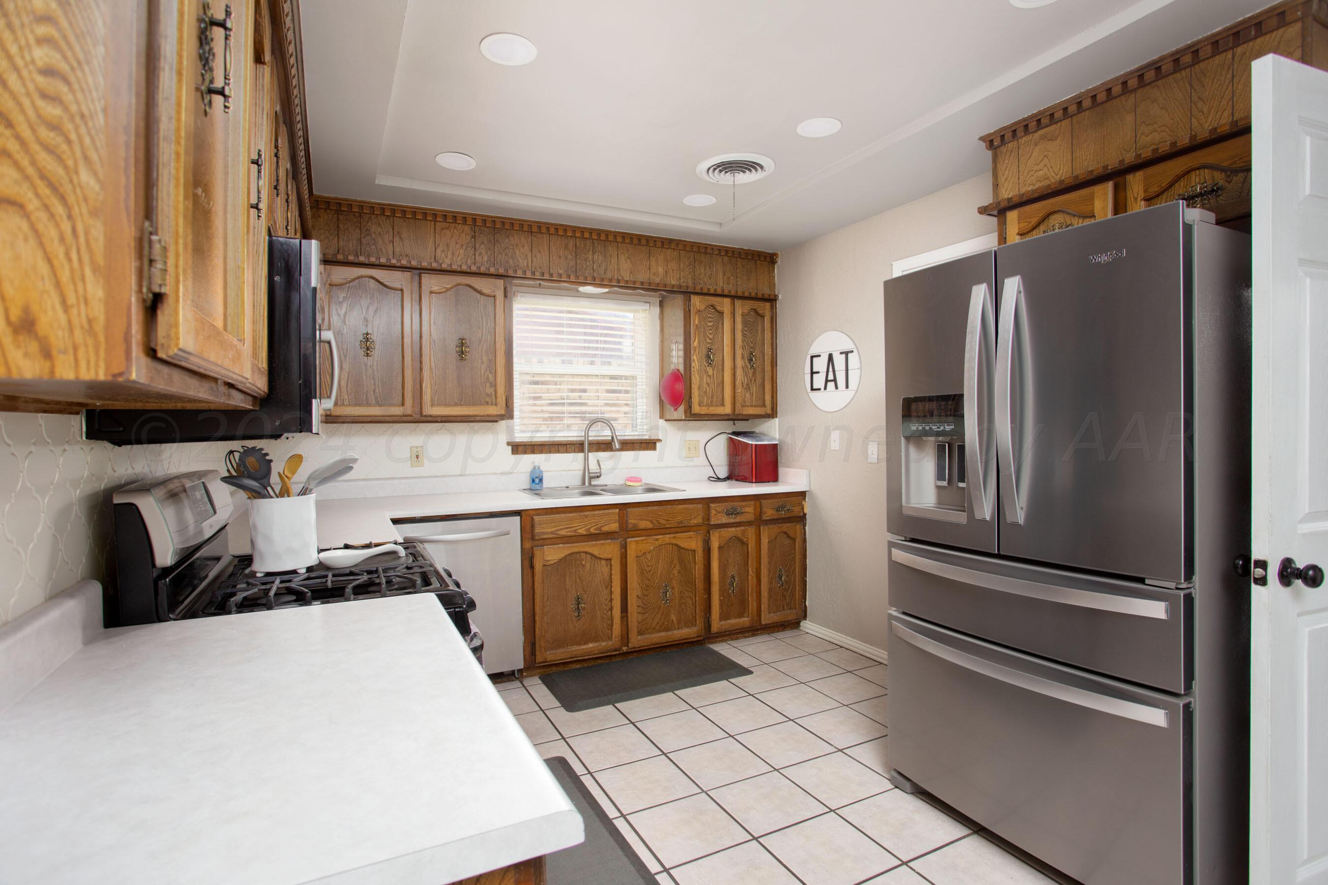 8122 Santa Fe Trail Amarillo, TX 79110 - Photo 5 of 23 a kitchen with a refrigerator a sink and cabinets