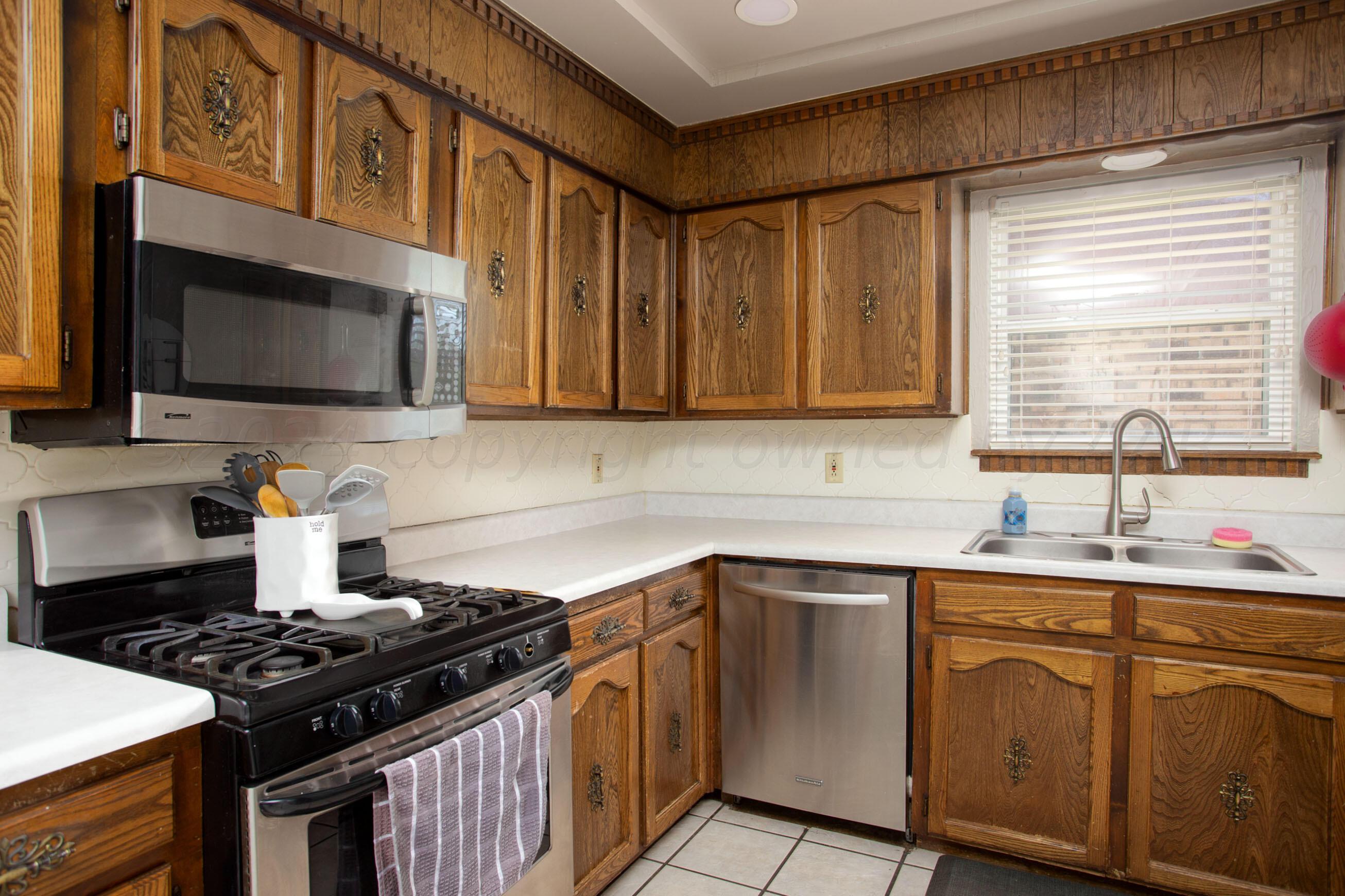 8122 Santa Fe Trail Amarillo, TX 79110 - Photo 6 of 23 a kitchen with stainless steel appliances a sink stove and microwave