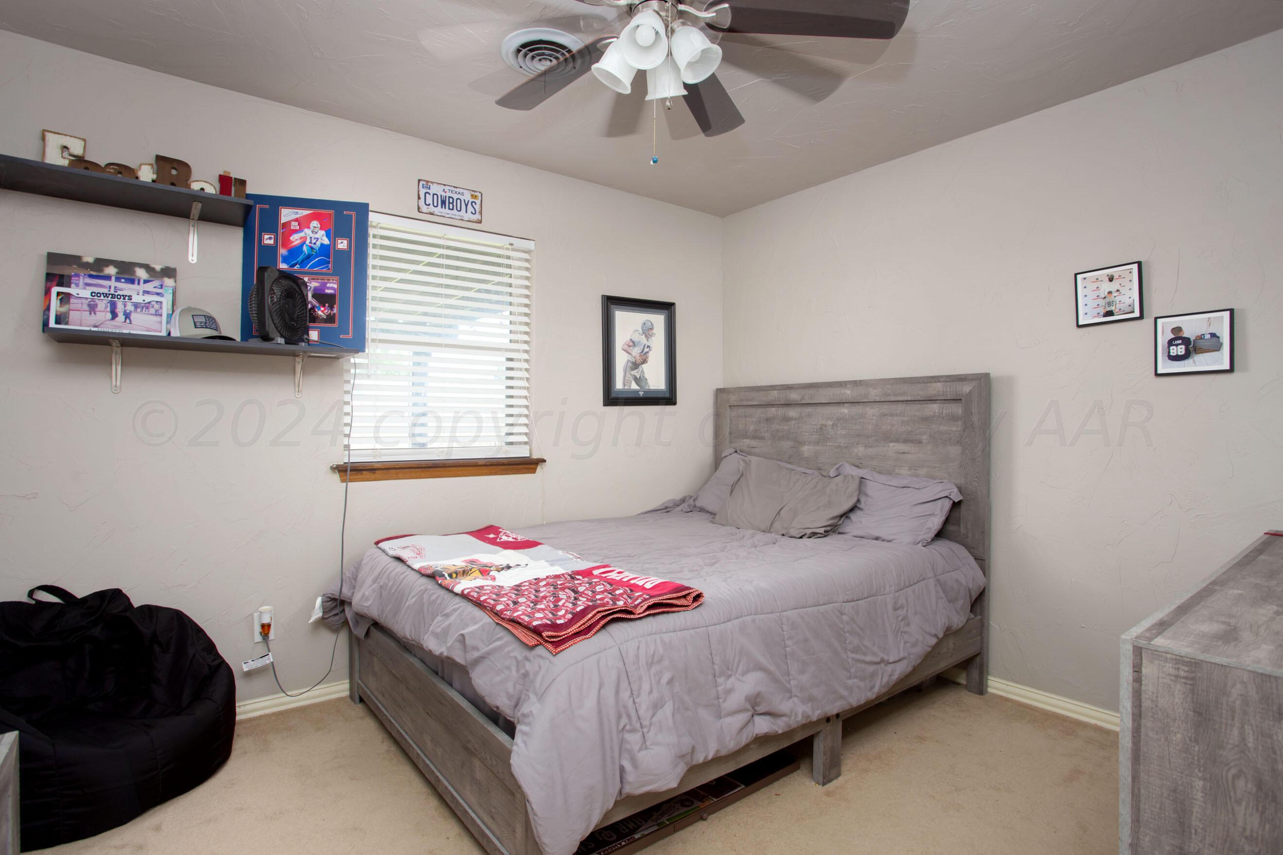 8122 Santa Fe Trail Amarillo, TX 79110 - Photo 10 of 23 a bedroom with a bed and a chandelier