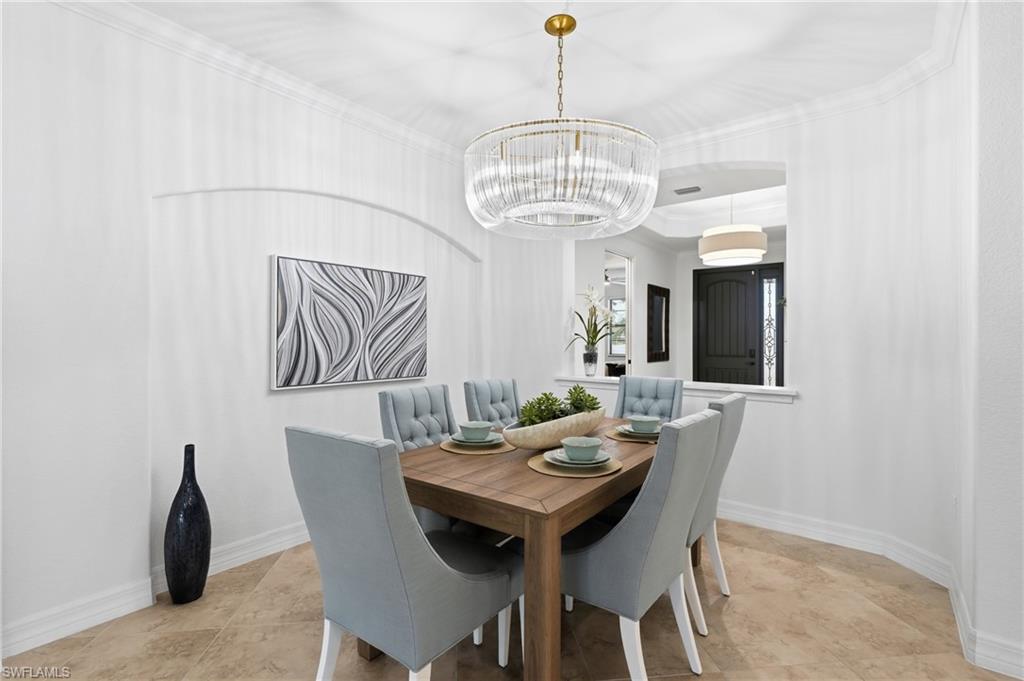9479 Piacere Way Naples, FL 34113 - Photo 14 of 48 Dining area featuring tile flooring, crown molding, a decorative wall niche, and a contemporary chandelier