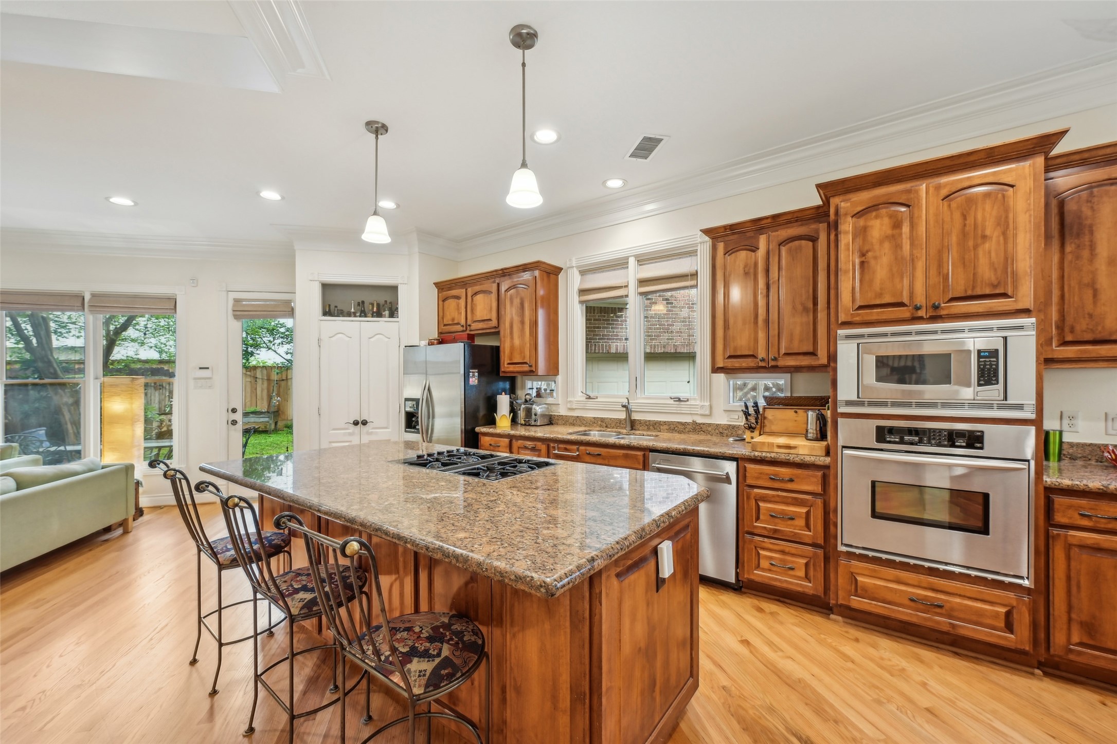 4026 Villanova Street Houston, TX 77005 - Photo 13 of 48 a kitchen with stainless steel appliances granite countertop a kitchen island hardwood floor sink stove dining table and chairs