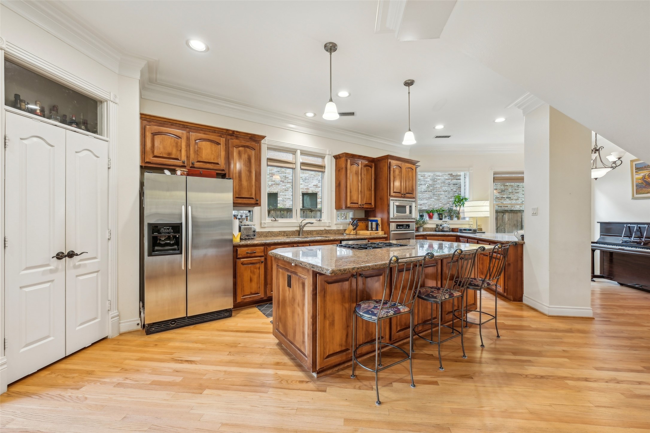 4026 Villanova Street Houston, TX 77005 - Photo 9 of 48 a kitchen with stainless steel appliances granite countertop a refrigerator a stove a sink a dining table and chairs with wooden floor