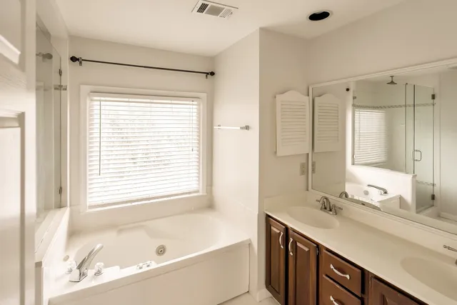 a bathroom with a tub sink and mirror