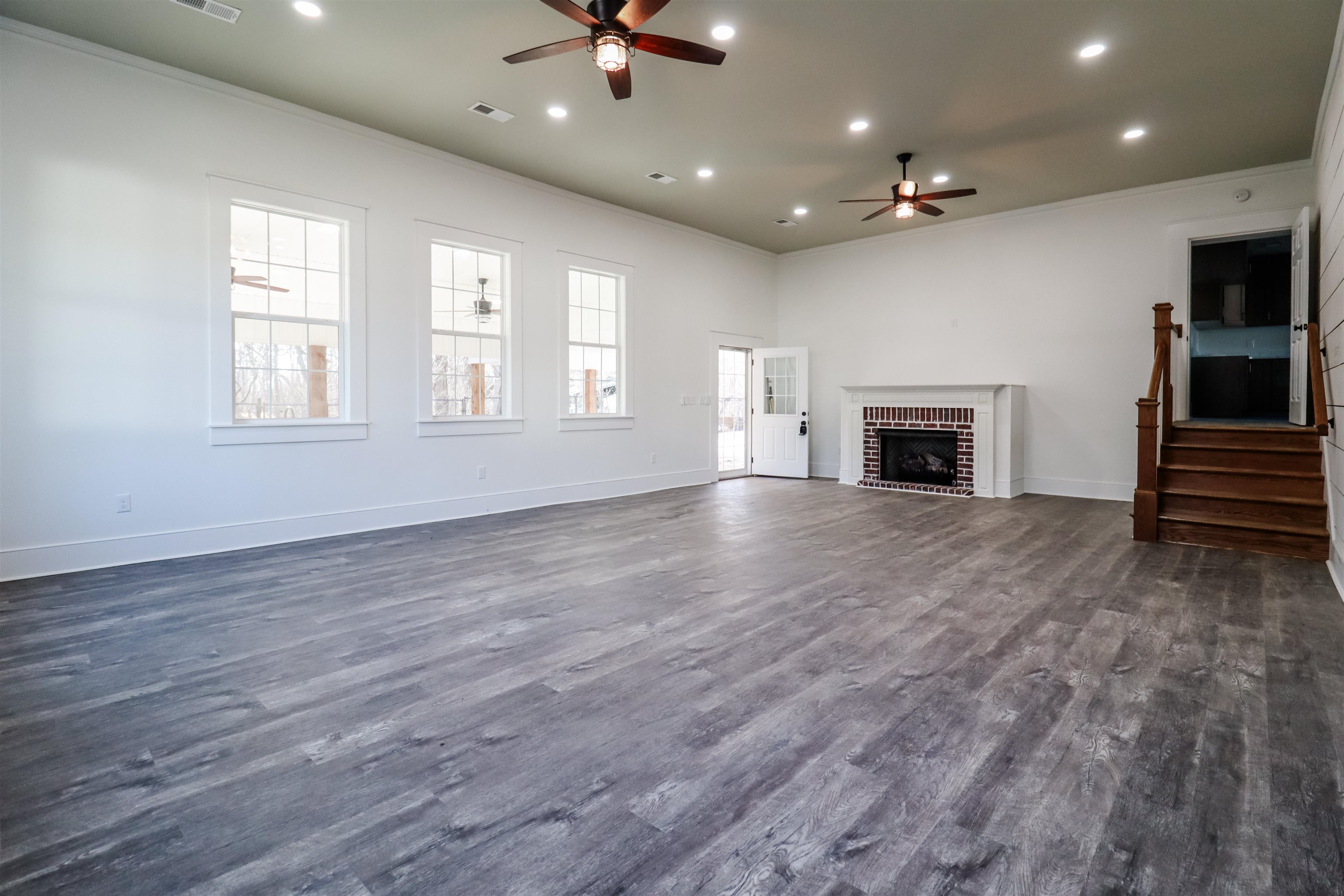 7237 Edith-Nankipoo Road Ripley, TN 38063 - Photo 12 of 31 an empty room with wooden floor fireplace and windows