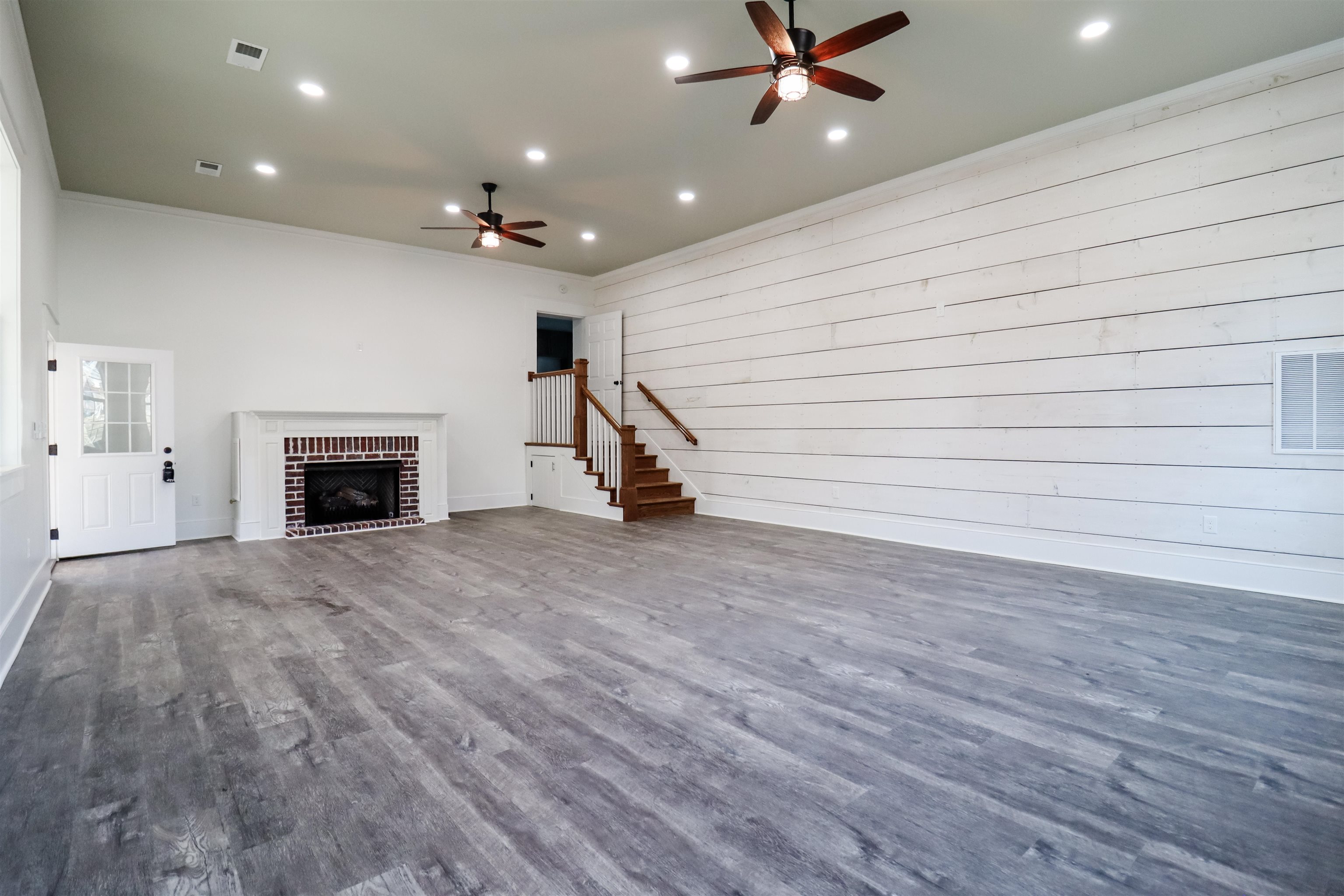 7237 Edith-Nankipoo Road Ripley, TN 38063 - Photo 14 of 31 an empty room with wooden floor a ceiling fan a fireplace and windows