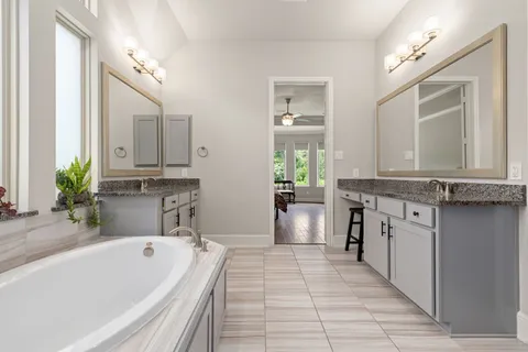 a bathroom with a tub sink and mirror