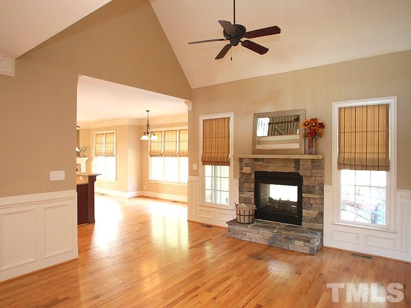 2317 Finley Ridge Lane Raleigh, NC 27615 - Photo 4 of 23 a view of a livingroom with a fireplace a ceiling fan and wooden floor