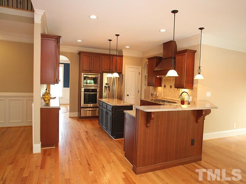 2317 Finley Ridge Lane Raleigh, NC 27615 - Photo 7 of 23 a large kitchen with stainless steel appliances kitchen island granite countertop a stove a sink a refrigerator and a wooden floors