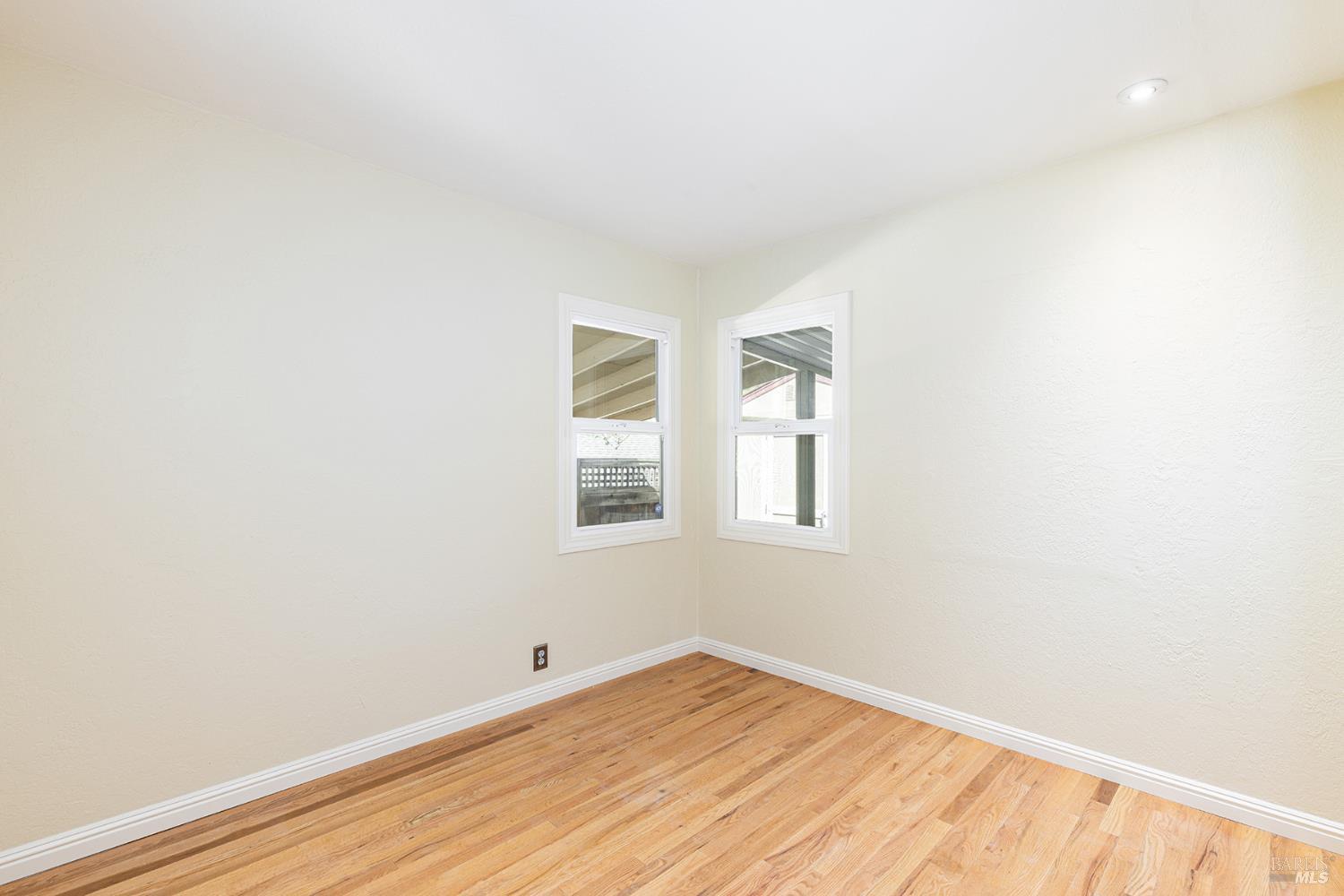 18090 Las Lomas Road Sonoma, CA 95476 - Photo 35 of 37 an empty room with wooden floor and windows