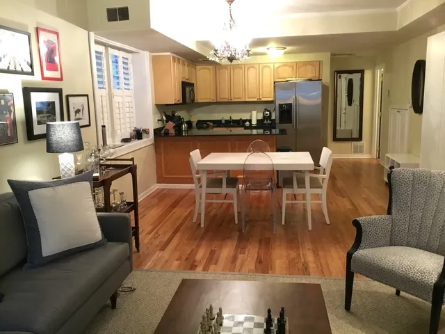 a dining room with wooden floor and stainless steel appliances
