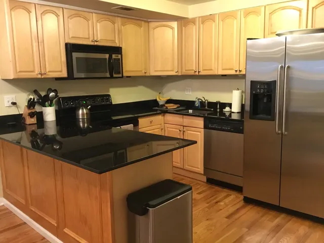 a kitchen with granite countertop a refrigerator stove and microwave