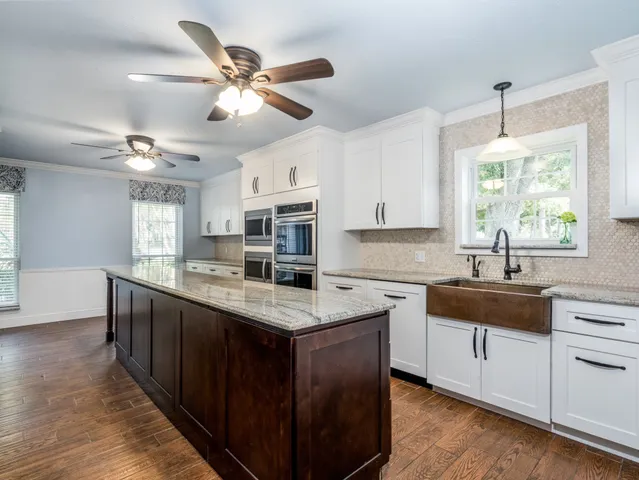 a kitchen with stainless steel appliances granite countertop a sink stove and cabinets