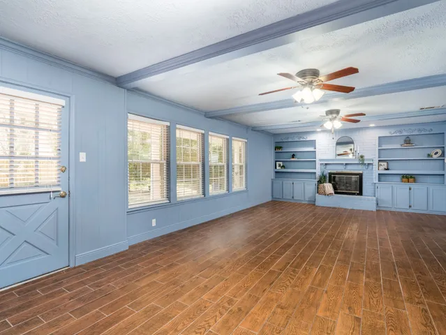 a view of an empty room with window and cabinet