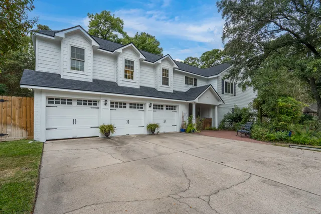 a view of a house with a yard and large tree