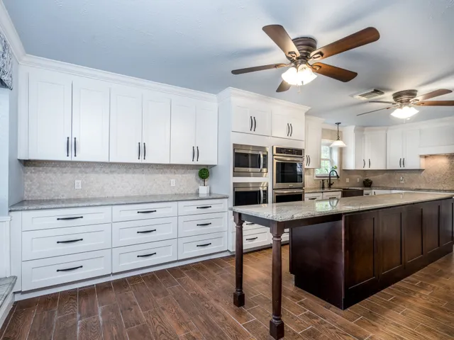 a kitchen with stainless steel appliances cabinets and a wooden floor