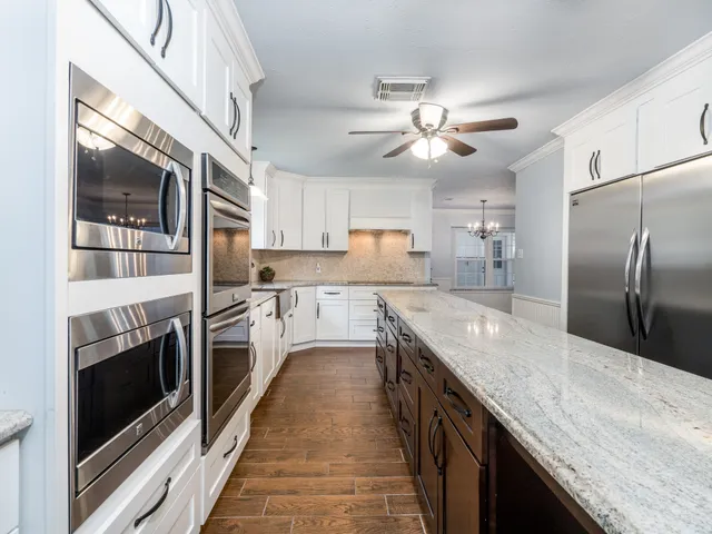a kitchen with stainless steel appliances granite countertop a stove a sink and a refrigerator