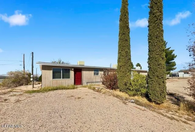 a front view of a house with a yard and tree s
