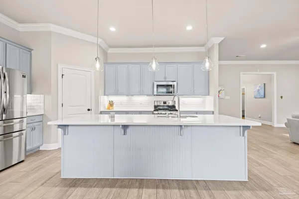 a kitchen with a sink cabinets and wooden floor