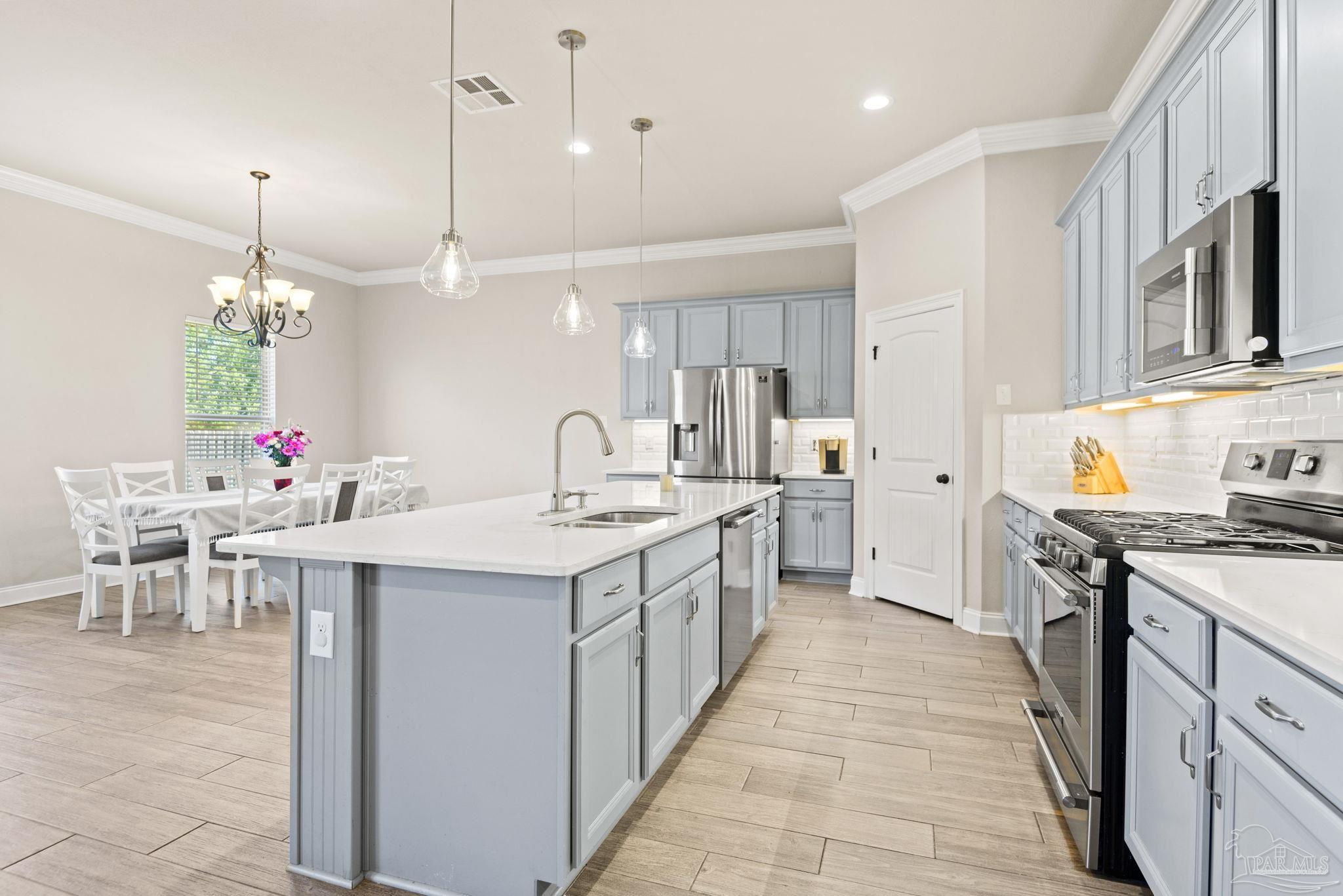 5912 Walter Franklin Road Pensacola, FL 32526 - Photo 19 of 51 a open kitchen with stainless steel appliances a stove center island a dining table and chairs