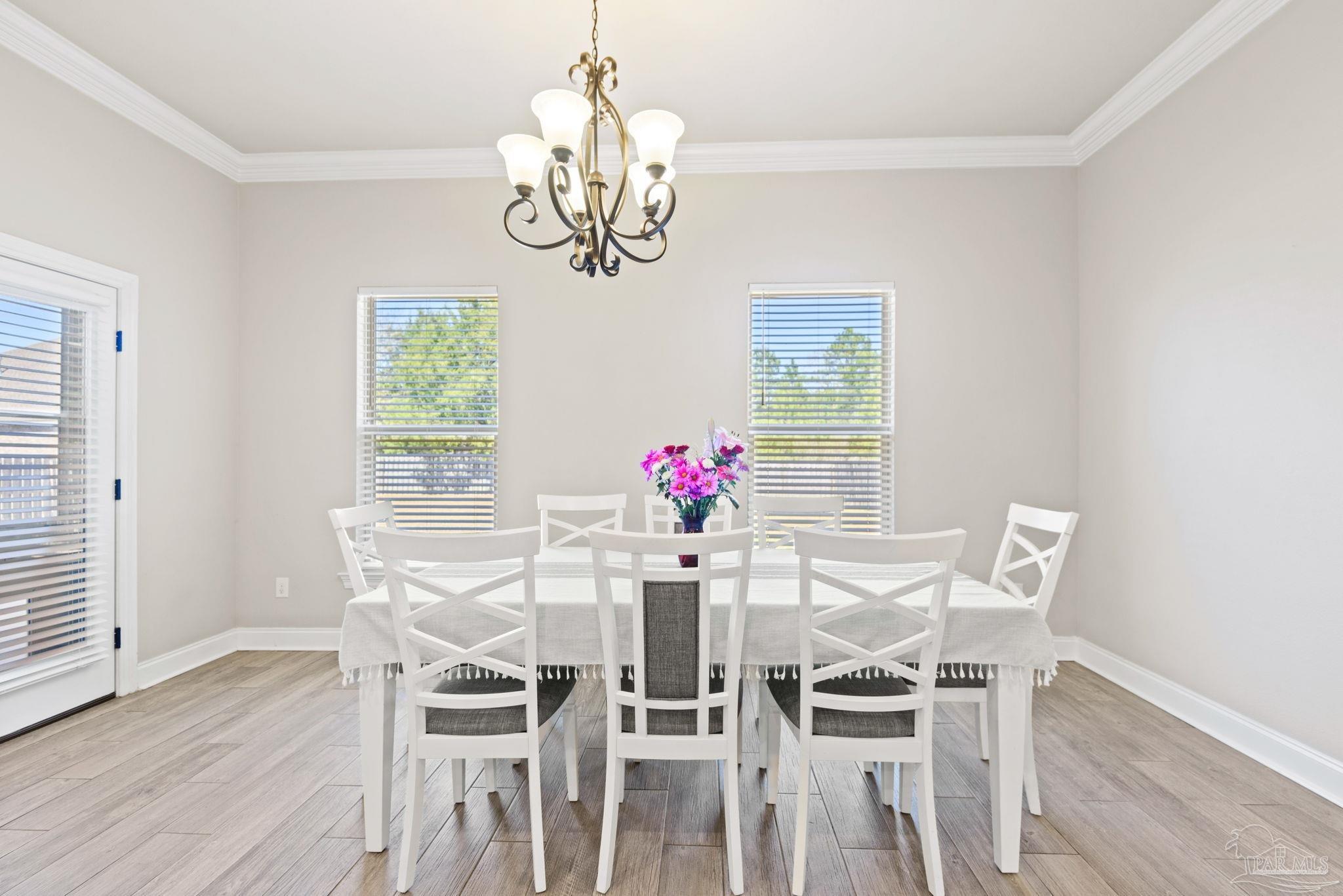 5912 Walter Franklin Road Pensacola, FL 32526 - Photo 21 of 51 a view of a dining room with furniture a chandelier and wooden floor