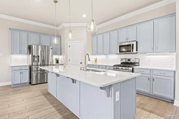 a kitchen with kitchen island a sink stainless steel appliances and cabinets