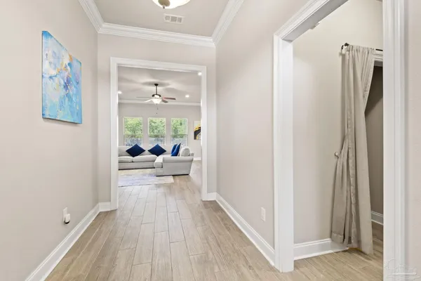 a view of a hallway with wooden floor and a bathroom